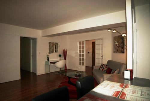 un salon avec un canapé et une table dans l'établissement Appartement Le Louvre, à Dijon