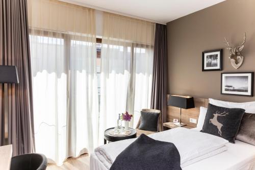 a bedroom with a bed and a large window at Best Western Plus Hotel Ostertor in Bad Salzuflen
