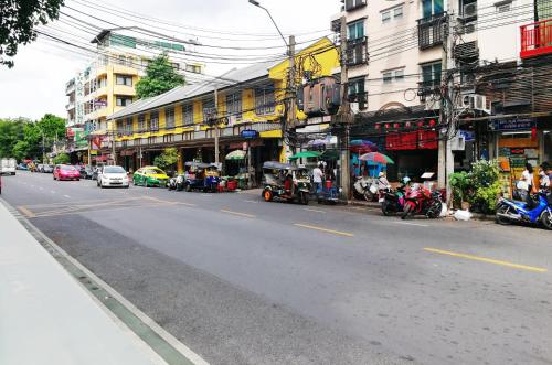 a city street with cars and motorcycles on the road at Casa Picasso Near Chabad House in Bangkok