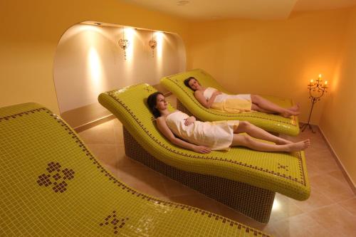 two women laying on chairs in a living room at Hotel Majolika in Modra