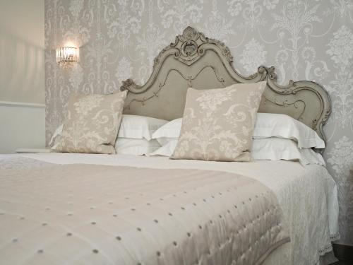 a bedroom with a white bed with white sheets and pillows at Le Sei Dame in Bardi