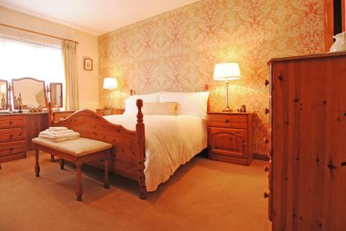 a bedroom with a bed and a table and a chair at Cottesmore Bed and Breakfast in Bushmills