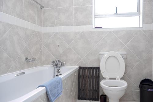 a bathroom with a toilet and a tub and a sink at Seabrook 210 in Margate