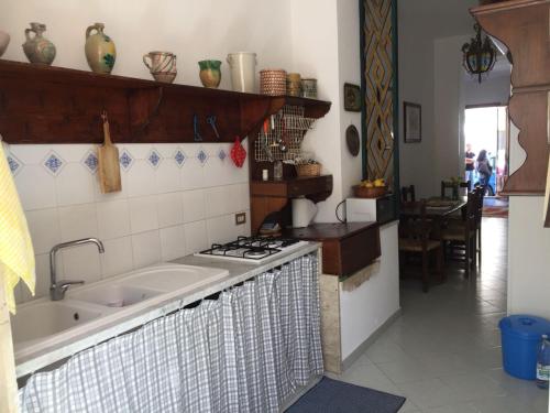 a kitchen with a sink and a stove top oven at Appartamento a due passi dal mare 8 posti letto in San Vito lo Capo