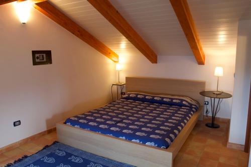 1 dormitorio con 1 cama en una habitación con techos de madera en La Torretta, en Casal Velino