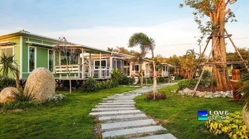 a house with a stone path in front of a house at Phalagoon Resort in Ban Chang