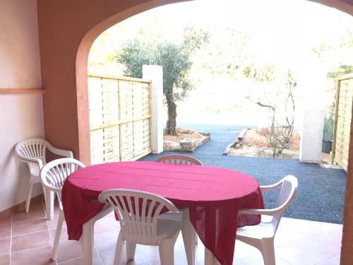 - une table avec des chaises et un chiffon de table violet sur la terrasse dans l'établissement Appartement 300mètres mer Martinengo La Croisette, à Sainte-Maxime