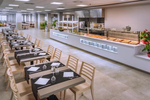 una fila de mesas en un restaurante con buffet en Hotel Sorra Daurada Splash, en Malgrat de Mar