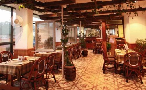 a restaurant with tables and chairs in a room at Hotel Centre Point in Shillong