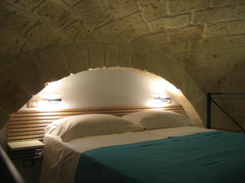 een slaapkamer met een bed met een bakstenen muur bij Antico Molino in Trani