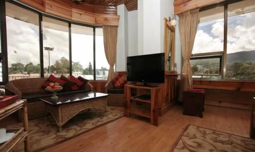 a living room with a couch and a flat screen tv at Hotel Centre Point in Shillong
