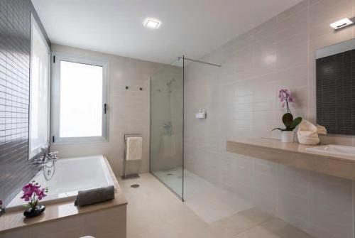 a bathroom with a tub and a shower and a sink at Vista Golf 15 in La Playa de Arguineguín