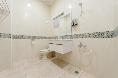 a bathroom with a shower and a toilet and a sink at T. T. House in Hengchun