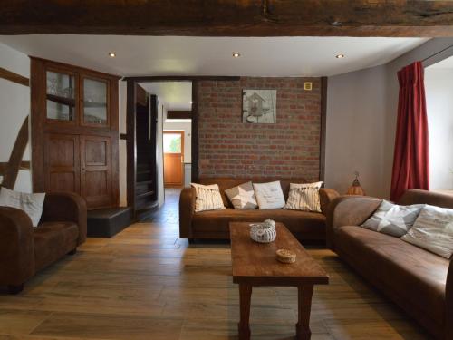 sala de estar con sofás y pared de ladrillo en Charming cottage near famous Francorchamps, en Francorchamps