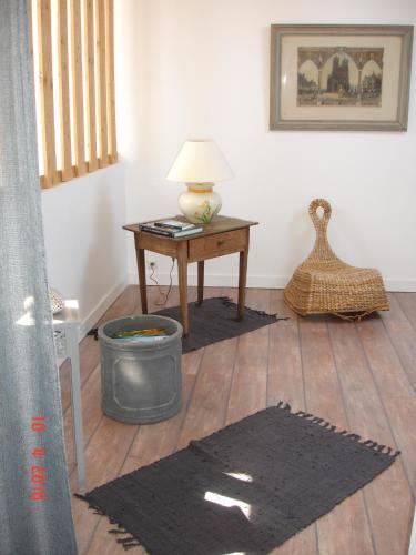a room with a desk and a table with a lamp at LA MAISON D'ISABELLE in La Fresnais