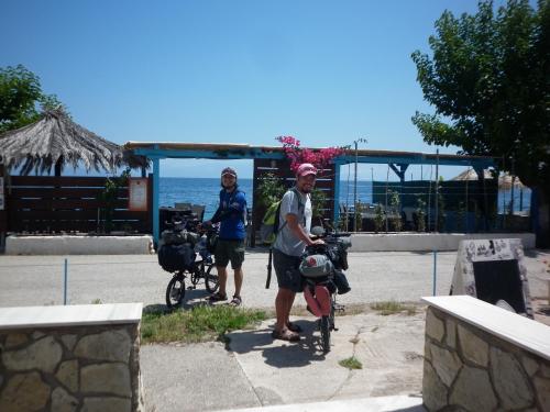 two people standing with their bikes in front of a building at Akri Rooms in Akrata