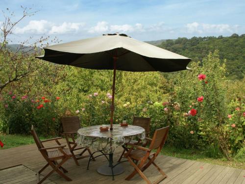 a table and chairs with an umbrella on a deck at Tranquil Holiday Home in Corsica with Terrace in Penta-di-Casinca
