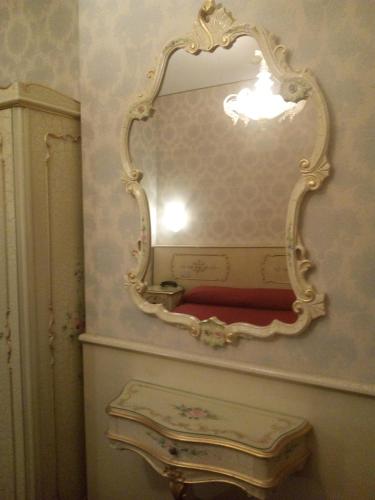 a mirror on a wall in a bathroom with a sink at Hotel Diana in Venice
