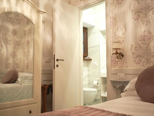 a bedroom with a bed and a toilet and a mirror at Le Sei Dame in Bardi