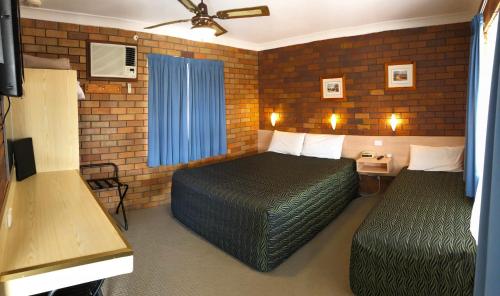 a hotel room with two beds and a window at Peter Allen Motor Inn in Tenterfield