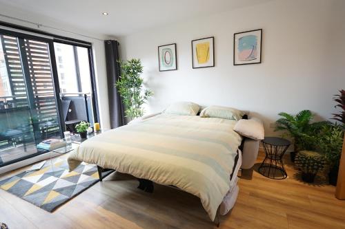 a bedroom with a bed and a large window at Perfectly located stunning apartment in London