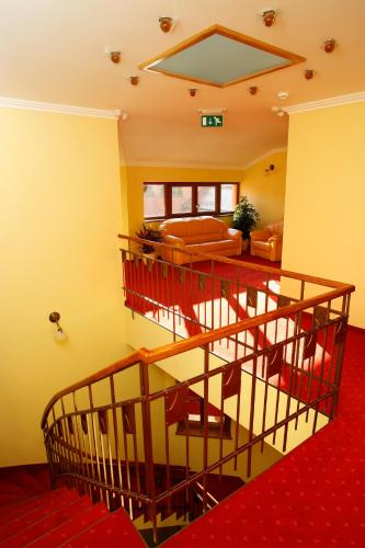 a room with a staircase and a living room at Hotel Majolika in Modra