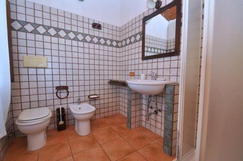 a bathroom with a sink and a toilet and a mirror at Residence in Gallura in Badesi