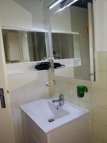 une salle de bain avec un lavabo blanc et un miroir dans l'établissement Cap Confort, au Cap d'Agde