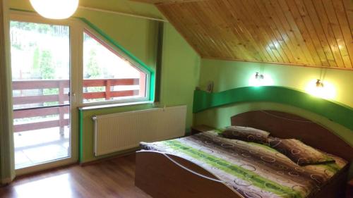 a bedroom with a bed and a large window at Casa de vacanța in Paraul Rece