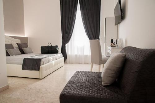 - une chambre avec un lit, un canapé et une fenêtre dans l'établissement Lifestyle Veneto Suite, à Rome