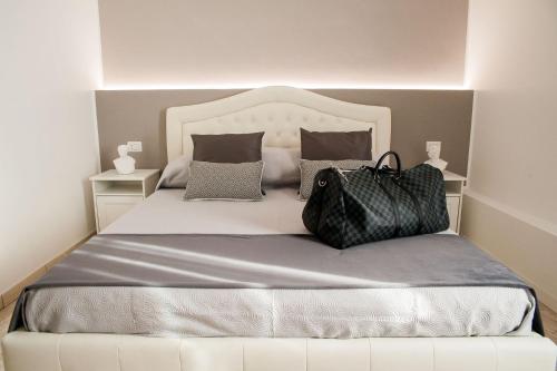 Una cama con dos bolsas sentadas encima. en Lifestyle Veneto Suite en Roma
