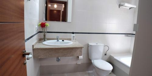 a bathroom with a sink and a toilet and a mirror at Zambra. Luminoso y coqueto apartamento en Chiclana in Chiclana de la Frontera