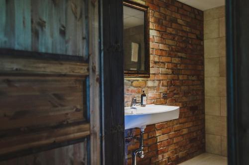 a bathroom with a stone wall and a wooden door at Lydinge Resort in Hyllinge