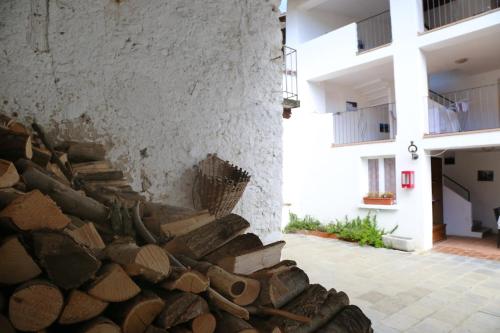 a wall with a pile of wood next to a building at B&B Rocca di Bajedo in Pasturo
