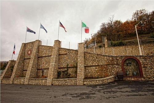 a stone wall with flags on top of it at Afkos Grammos Boutique Hotel Resort in Nestórion