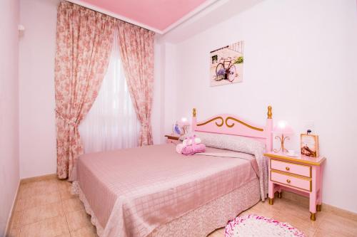 トレビエハにあるEspanatour Doloresのピンクのベッドルーム(ベッド1台、ドレッサー、窓付)が備わります。