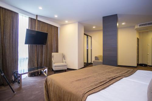 a bedroom with a large bed and a tv in it at Maristella Marine Residence in Odesa