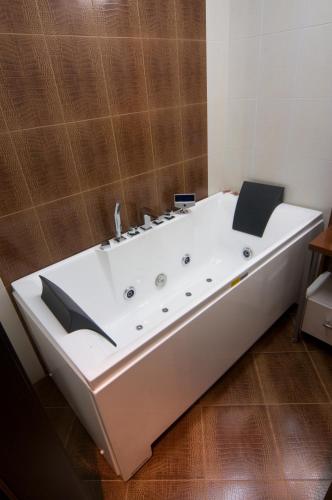 a large white bath tub sitting in a bathroom at Hotel Ženeva Lux in Kragujevac