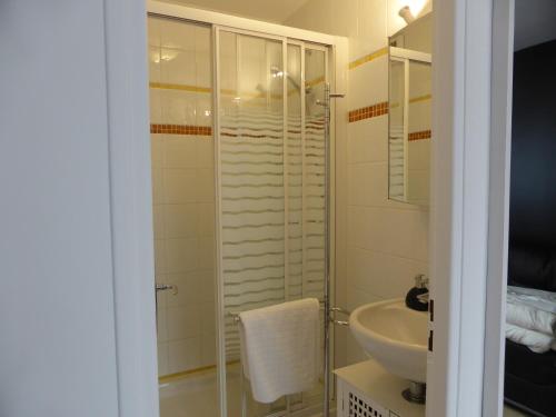 uma casa de banho com um chuveiro, um lavatório e um WC. em Une chambre à Neuilly Guest house em Neuilly-Plaisance