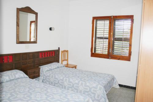 sypialnia z 2 łóżkami, lustrem i oknem w obiekcie Crisson w mieście L'Escala