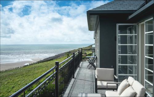 a balcony with chairs and a view of the beach at Chalet Saunton in Braunton