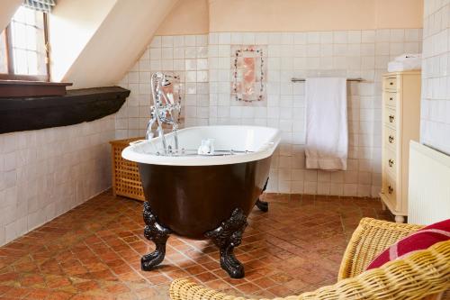 Cette chambre comprend une salle de bains pourvue d'une grande baignoire. dans l'établissement Burford House BH, à Burford