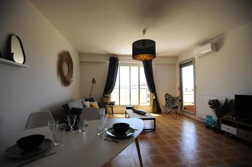 un salon avec une table blanche et un salon dans l'établissement T2 Terrasse Vue Mer - Route des Sanguinaires, à Ajaccio