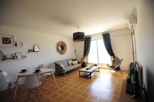 una sala de estar con un sofá y una mesa en T2 Terrasse Vue Mer - Route des Sanguinaires, en Ajaccio