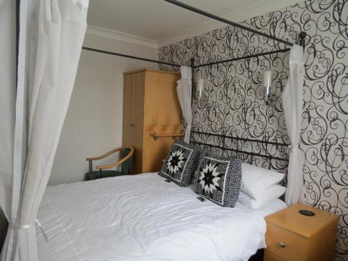 a bedroom with a white bed with black and white pillows at The Royal Bridlington in Bridlington