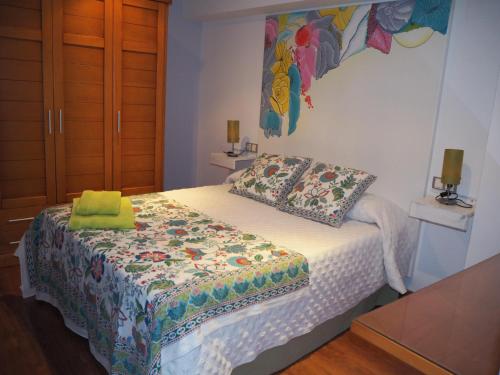 a bedroom with a bed with a comforter on it at La Casa El Yelmo De Mambrino in Campo de Criptana