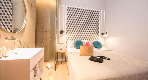 a room with two beds and a bathroom with a sink at Mosaic by Ona in Barcelona