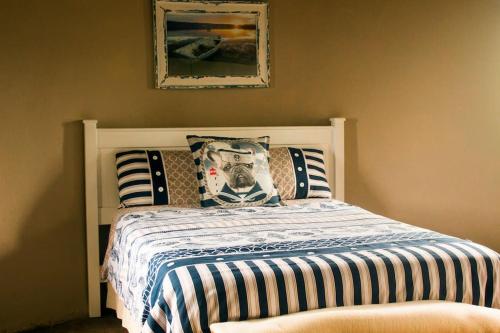 a bedroom with a bed with striped sheets and pillows at Seaview Cottage in Coffee Bay