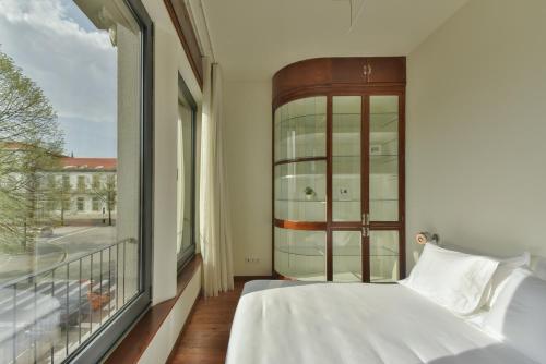 a bedroom with a bed and a large window at Republica 157 Guest House in Porto