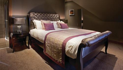 a bedroom with a large bed with purple pillows at The Parkville Hotel in Hamilton